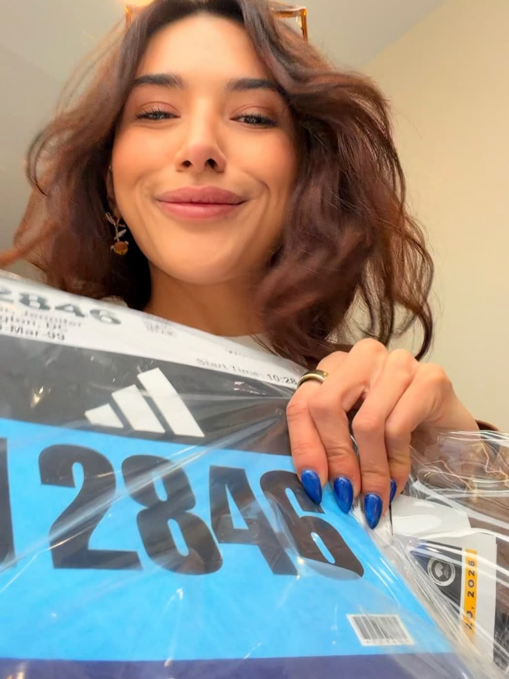 Jenn holding her Boston Marathon bib before the race