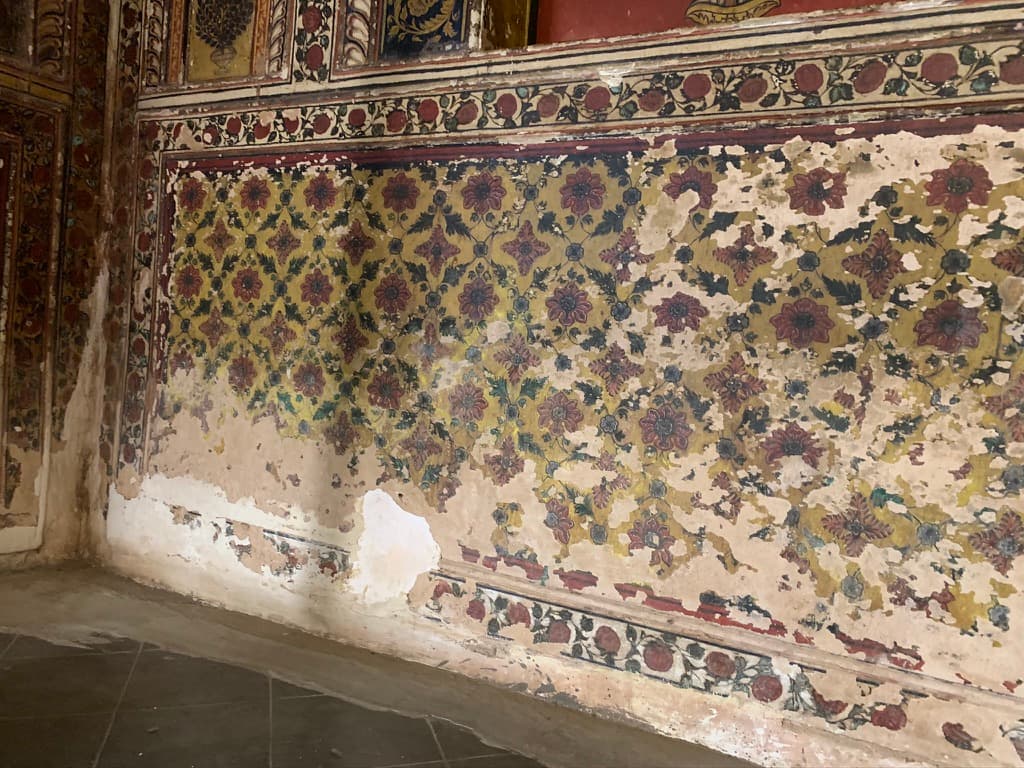 A weathered floral wall — two centuries of paint and plaster